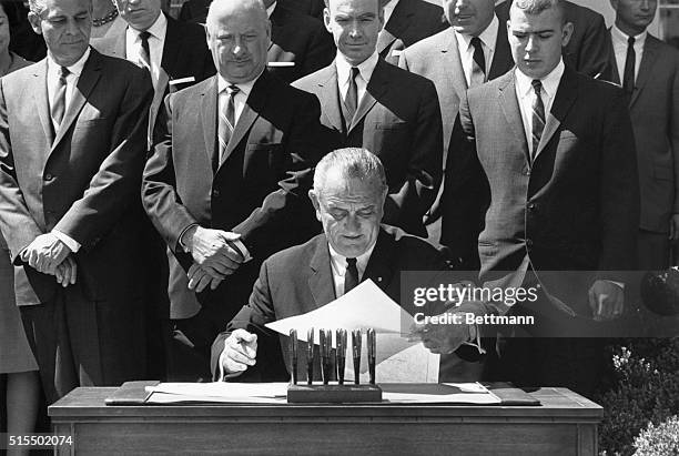 President Lyndon B. Johnson signs auto and highway safety act.