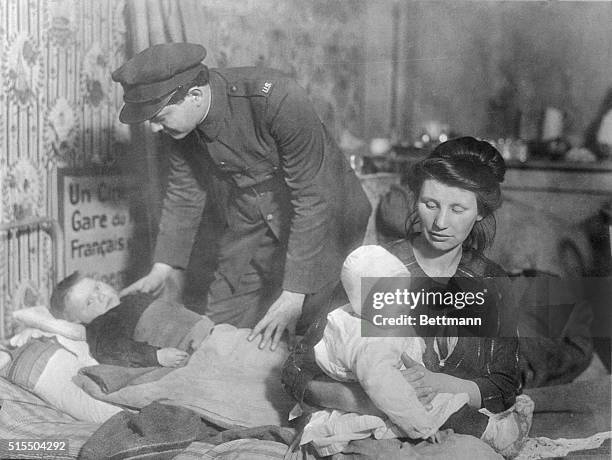 America aids the helpless...Many were the homeless who found shelter from the war under American care. This picture shows American Red Cross worker...