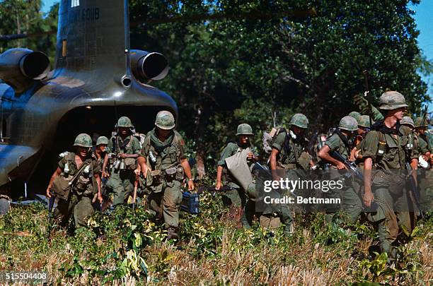 Soldiers disembarking from a troop transport helicopter in South Vietnam.