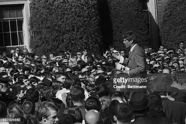 Senator Robert F. Kennedy holds a bullhorn in his hand as he shouts to a crowd outside the University of Nebraska's Memorial Coliseum, where he...