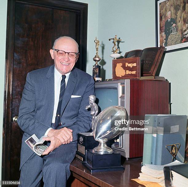 George Halas, owner/coach of the Chicago Bears at work in his office, outlining play on board for some of his coaches.