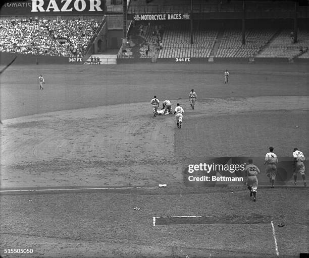 Lou Gehrig, of Yankees, flat on his back temporarily knocked out after being tagged on the temple by Lyn Lary, Indians shortstop, who made the putout...