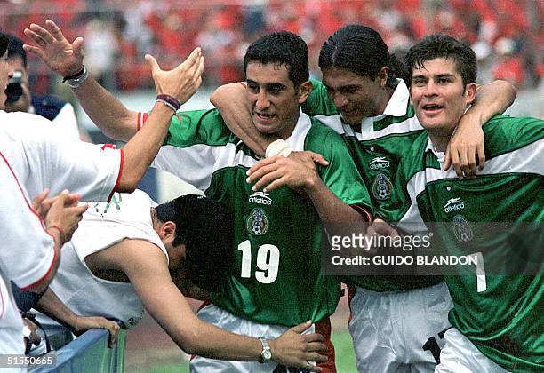 Miguel Zepeda of Mexico is embraced by teammates Raul Ramirez and Francisco Palencia after scoring the goal of victory against Panama 16 July, 2000...