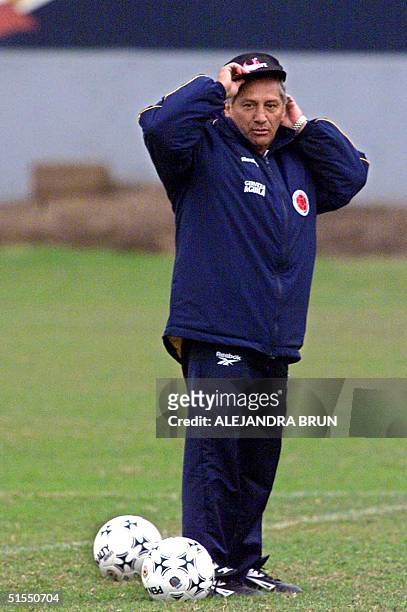 Trainer of the Colombian soccer team Luis "Chiqui" Garcia adjusts his cap during a training session of the team in Lima 17 July, 2000. Colombia will...