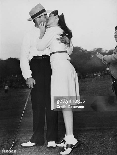 Los Angeles, California: Sammy Snead as he received a big kiss as an added prize for winning the L. A. Open Golf championship here, from Mary Ann...