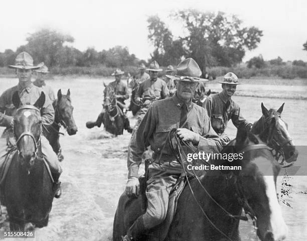 General John Pershing and his staff ford a river on horseback. Undated photograph. BPA2# 5162