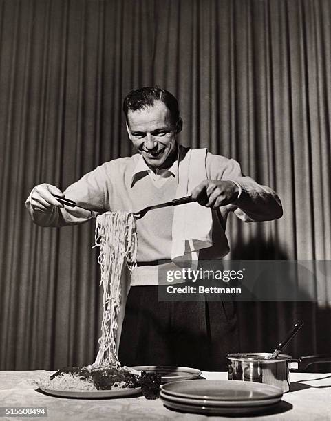 FRANK SINATRA DISHING OUT SPAGHETTI.UNDATED PHOTOGRAPH.