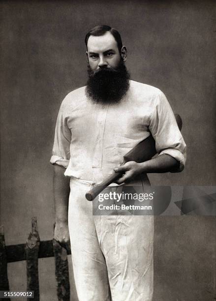 The champion English cricketer, W.G. Grace, posing with his cricket bat and wearing traditional white uniform, in 1887.