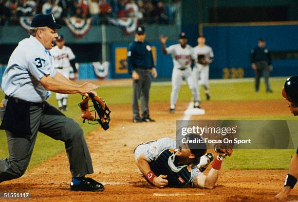 Brian Harper of the Minnesota Twins shows the ball to the umpire after a play at home plate during the World Series against the Atlanta Braves during...