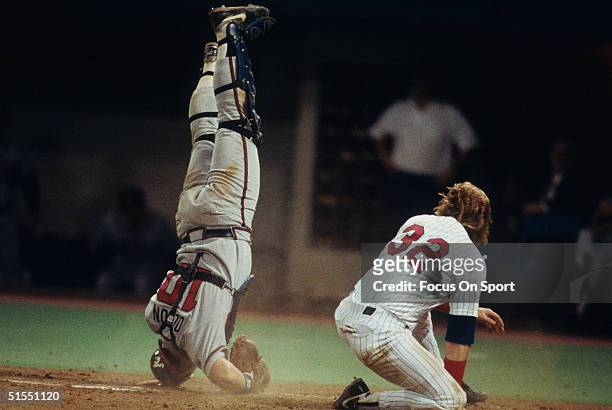 Dan Gladden of the Minnesota Twins knocks over catcher Greg Olson of the Atlanta Braves at home base as the run is settled at home base during the...