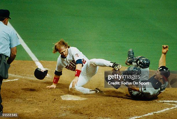 Dan Gladden of the Minnesota Twins mauls over Greg Olson, the catcher for the Atlanta Braves at home base during the World Series at the Metrodome in...