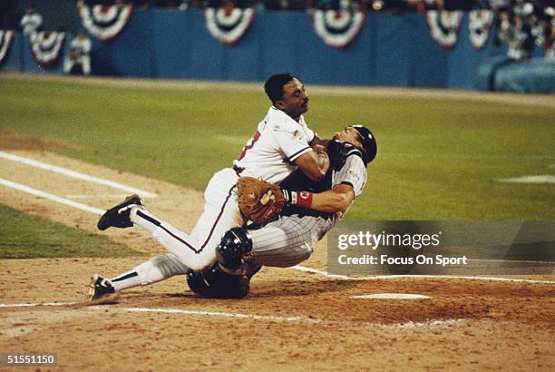 Lonnie Smith of the Atlanta Braves steamrolls over catcher Brian Harper of the Minnesota Twins at home plate during the World Series at Fulton County...