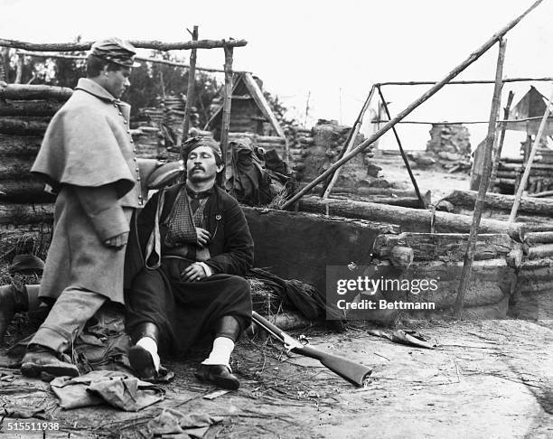 Member of a Confederate Civil War Zouave unit wears the distinctive uniform of baggy pants, decorative jacket, and fez. Standing at his side is a...