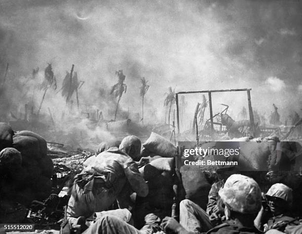 Tarawa- US Marines are seen firing from behind a sand bag entrenchment which they threw up as protection on the flat island of Tarawa where the...