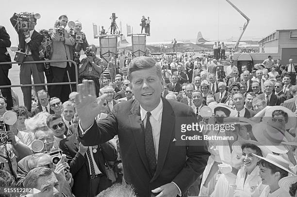 Los Angeles, California: Front running Sen. John F. Kennedy waves to cameraman upon his arrival at International Airport here where he will assume...