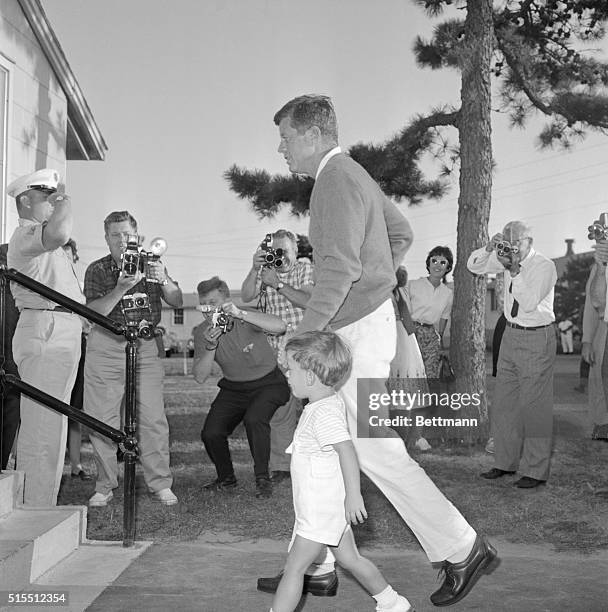President Kennedy leads his son, John Jr., into the Otis Hospital to visit the First Lady here. When the younger Kennedy reached the bottom of the...
