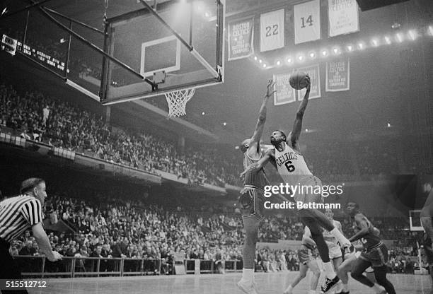 The Boston's Celtic's Bill Russell, goes in high to score as St. Louis Hawk's Zelmo Beaty, tries to block the attempt in a 2nd person action at the...