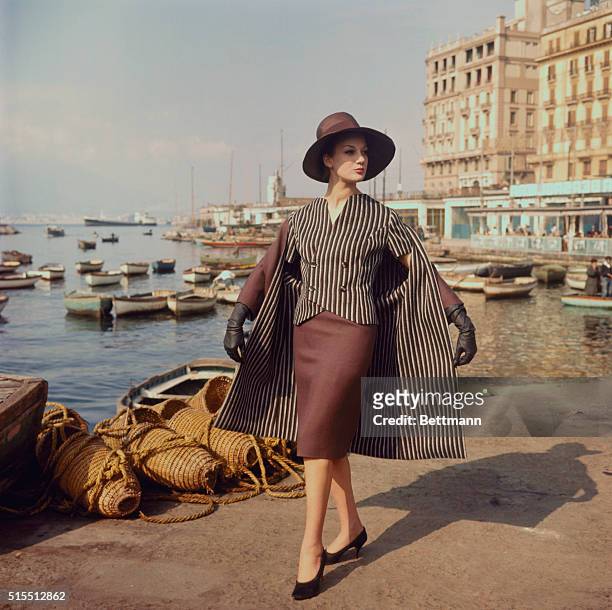 Star in Bars. Naples, Italy: Vertical bars of black and beige stripe the jacket and lining of a three-piece spring ensemble by Sarli of Naples. Short...
