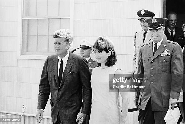President Kennedy escorts Mrs. Jacqueline Kennedy from base hospital here August 14. She had been in the hospital to have a son, Patrickl Bouvier...