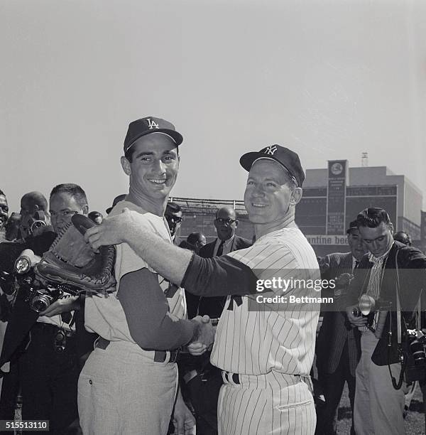 Starting pitchers Whitey Ford of the New York Yankees Sandy Koufax of the Los Angeles Dodgers shake hands before the fourth World Series game.