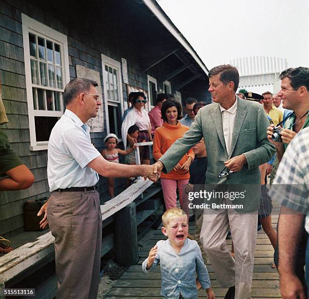 Hyannisport, MA.: Followed by a small crowd, Senator John F. Kennedy and his wife Jacqueline, stroll along pier going to their yacht Marlin for a...