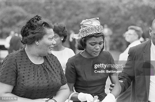 Birmingham, Alabama: Faces of two unidentified Negro women are contorted by grief, as they weep at cemetery where body of 14-year-old Carol Robertson...