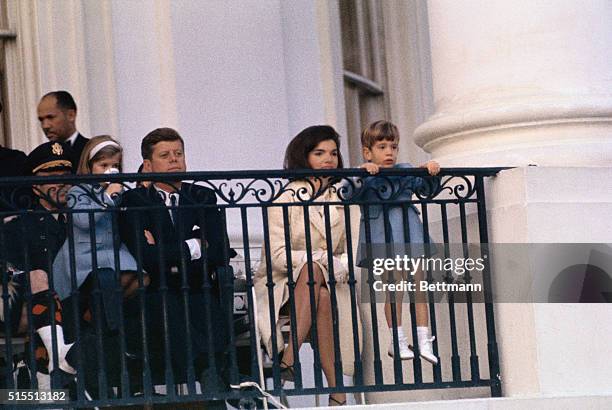 President and Mrs. Kennedy and their two children, Caroline and John, Jr., watch from the balcony here today, 11/13 as the Black Watch Royal Highland...