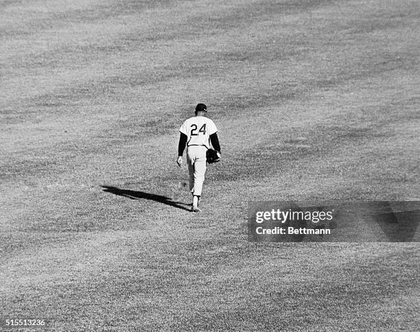 Willie Mays who cast a mighty shadow over center field for many years, makes the long slow solitary walk to the dressing room here on September 11th,...