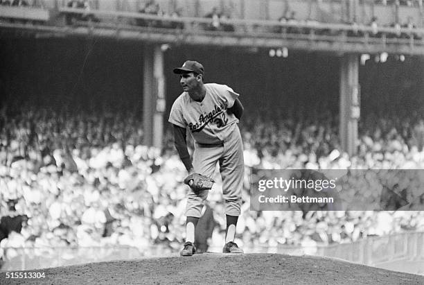 Los Angeles Dodger southpaw Sandy Koufax, who hurled his way into the record book 10/2, deliberates on the mound during epic performance in first...