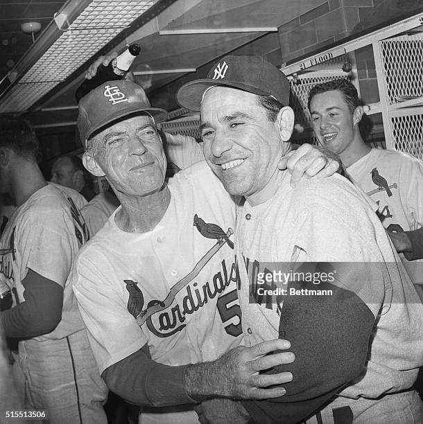 St. Louis Cardinals' manager Johnny Keane and New York Yankees' manager Yogi Berra embrace in Cards' dressing room October 15 following final series...