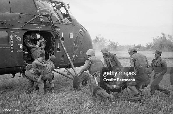 Soldier Rushing U.S. Marines rush wounded comrades to a waiting evacuation chopper ...