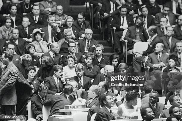 Mrs. Jacqueline Kennedy listens to Boston's Richard Cardinal Cushing as they wait in the United Nations General Assembly for the address by Pope Paul...