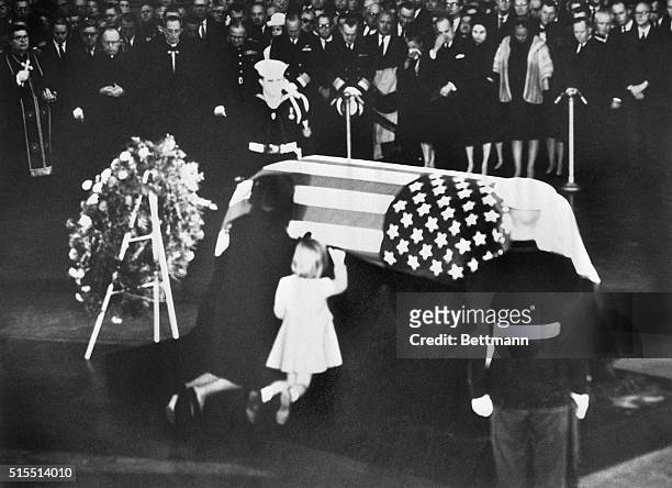 Jacqueline and Caroline Kennedy, wife and daughter of assassinated president John F. Kennedy, kneel at his coffin.