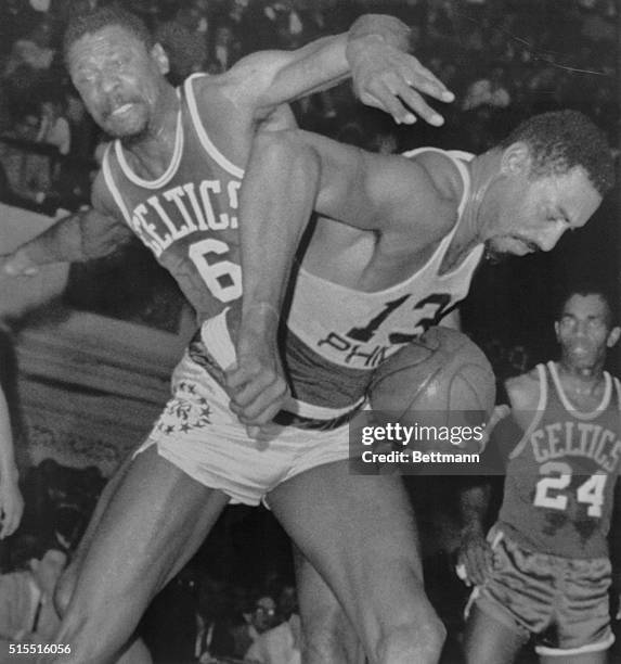 Philadelphia: A Battle Of Titans: 76ers Wilt Chamberlain fights his $100,000 counterpart, Celtic Bill Russell for a rebound during the first quarter...