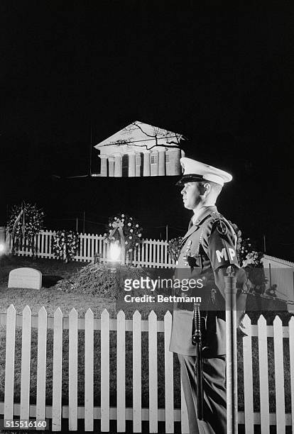Arlington, VA.: Every day since the burial Nov. 25 a member of the Armed Forces has stood near the flaming torch which marks the grave of President...