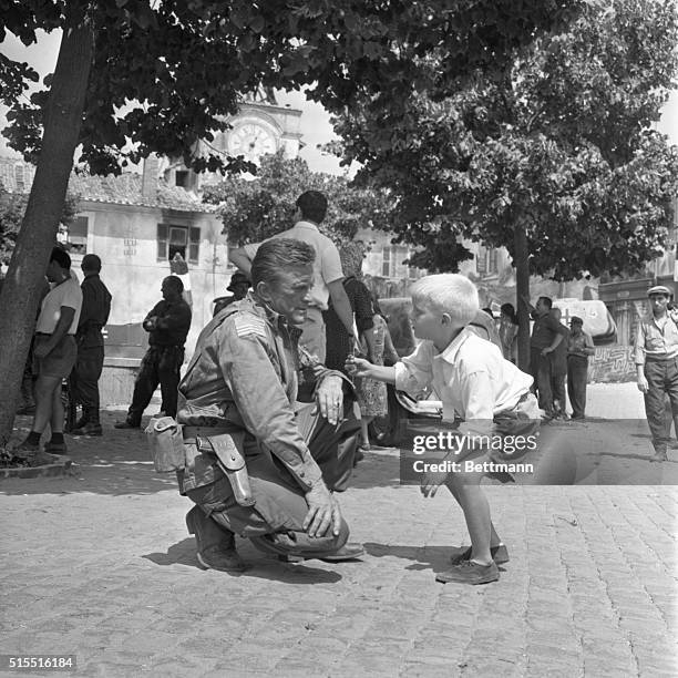 Eric Douglas presents a tiny Israeli flag to his father, Kirk Douglas, in an off moment from the cameras of "Cast a Giant Shadow" being filmed near...