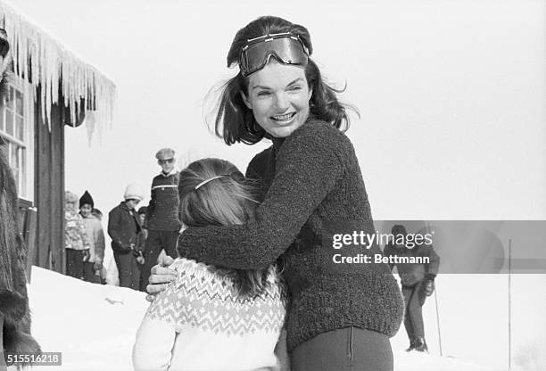 Mrs. Jacqueline Kennedy laughs and embraces her daughter, Caroline, as the Kennedy family enjoys a ski holiday.