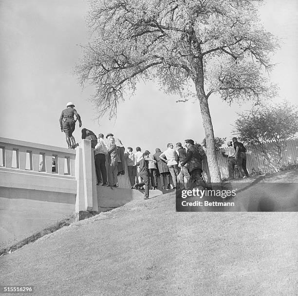 Onlookers at the corner of the Stockade Fence and the Triple Underpass after the assassination of President Kennedy.