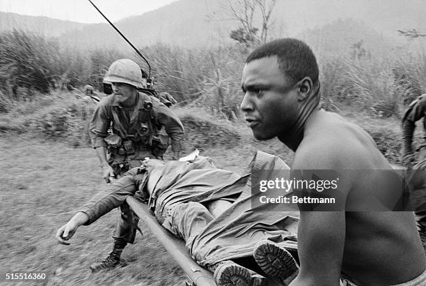 Grim faced U.S. 1st Cavalry medical orderlies rush wounded comrade to waiting evacuation helicopter, as operation White Wing continues.