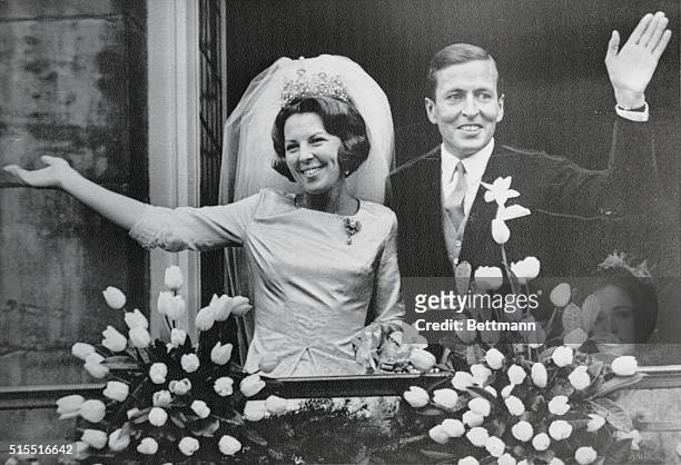 Crown Princess Beatrix and her husband Claus Von Amsberg wave from a balcony of the Royal Palace following their wedding on March 10, 1966 in...