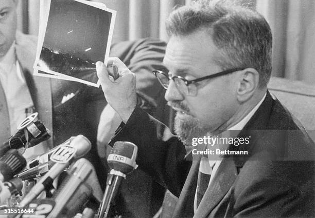 Dr. H. Allen Hynek, a Northwestern University astrophysicist, tells newsmen at a press conference here that the photograph he is holding is a time...