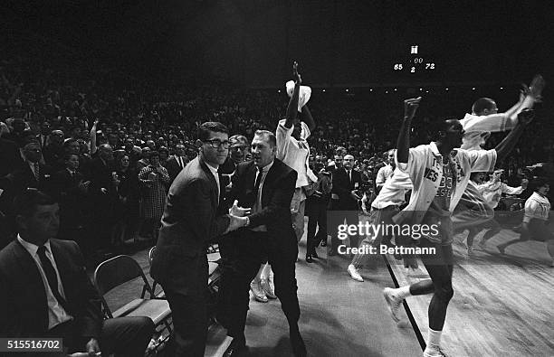 Members of Texas Western rush onto the court as the final gun sounded giving them a 72-65 win over the Kentucky Wildcats and the NCAA basketball...