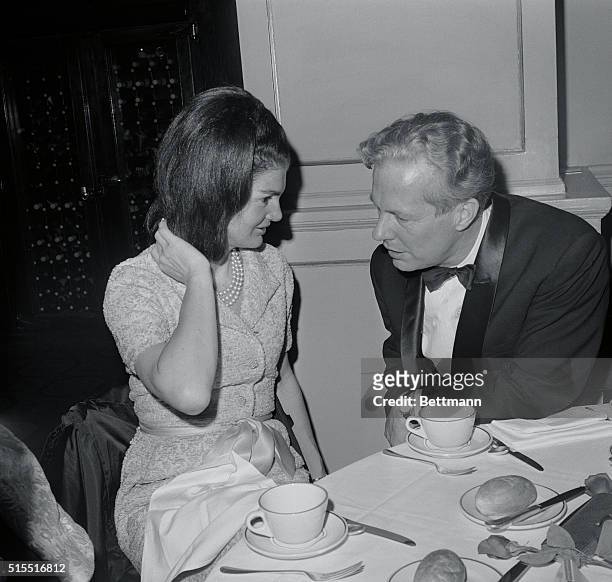 Chat. New York: Mrs. Jacqueline Kennedy fixes her hair as she chats with Harold Taylor, president of the American Ballet Theatre. Mrs. Kennedy was...