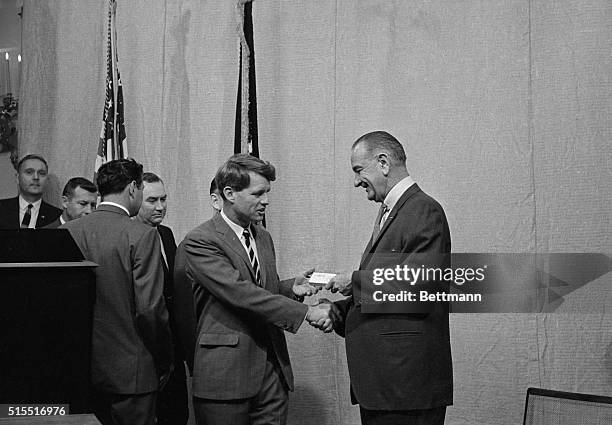 President Johnson hands a pen to senator Robert F. Kennedy, D-N.Y. After the Chief Executive signed into law the cold war G.I. Bill of Rights at the...