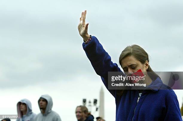 Christian Liz Robertson of Atlanta, Georgia raises her hand as she worships during the "America for Jesus" rally October 22, 2004 at the National...