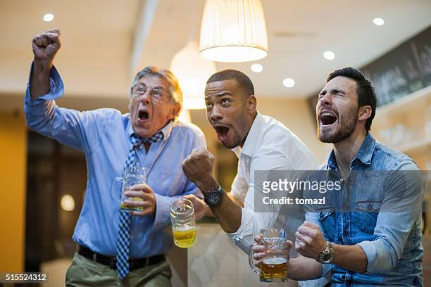 verzückt männer beobachten soocer spiel in die bar nach der arbeit - altbier stock-fotos und bilder