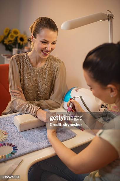 happy woman in nail salon enjoying during manicure treatment. - nail salon stock pictures, royalty-free photos & images