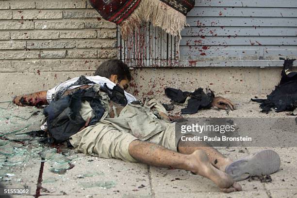 The corpse of a suicide bomber lays on a commercial shopping street October 23, 2004 in Kabul, Afghanistan. The blast killed a 12-year-old girl and...
