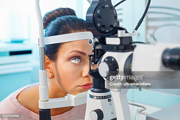 at the optician   ophthalmology   doctor ophthalmologist   optometrist medical eye examination - medical laser stockfoto's en -beelden