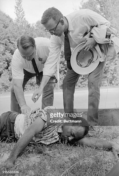Sherwood Ross , a Washington public relations advisor, and an unidentified police officer examine the wounds of African American student James...